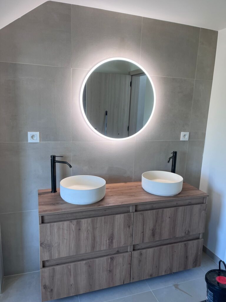 Moderne badkamer met dubbele wastafel en verlichte spiegel